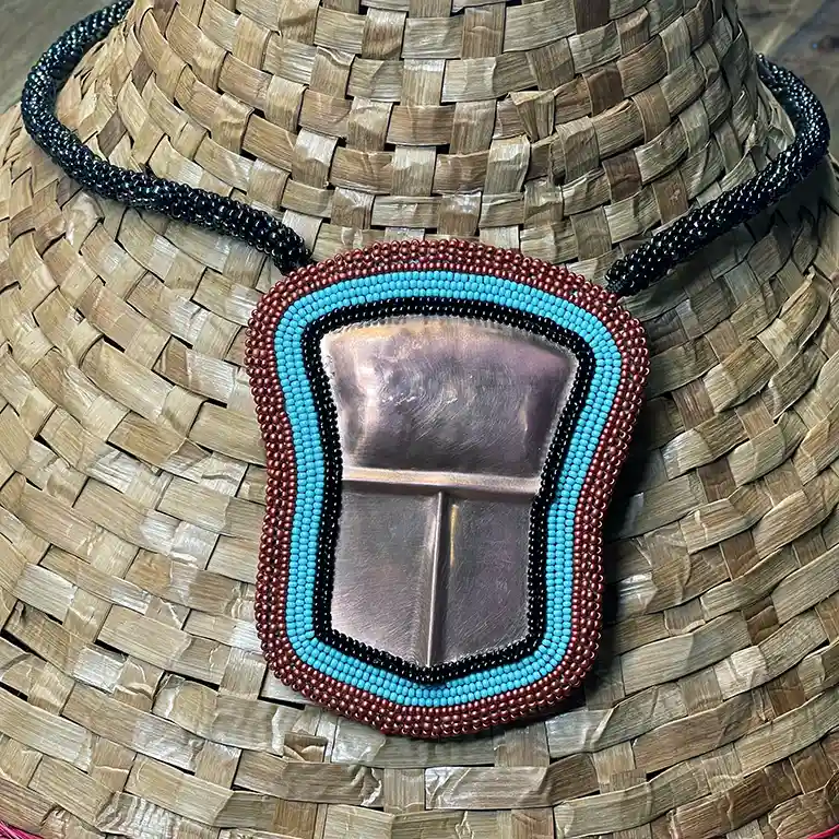 Thumbnail size Beaded Tlingit Tinaa shown on a weaved cedar hat.